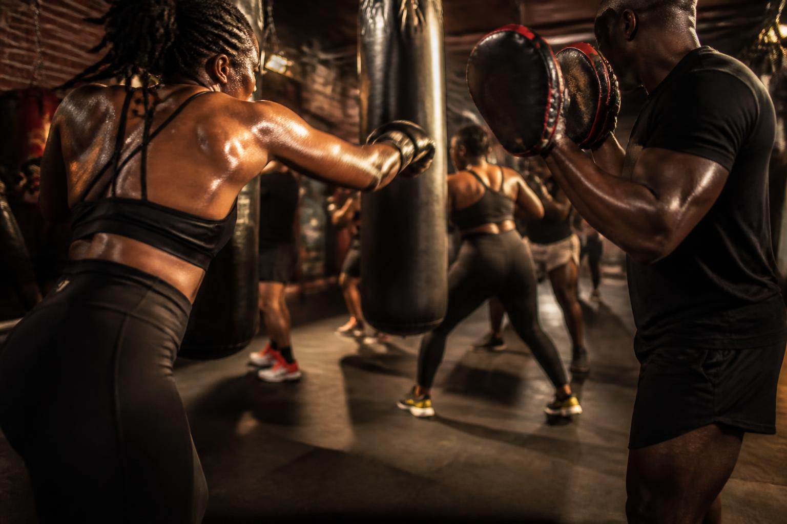 Adults striking heavy bags in a kickboxing class